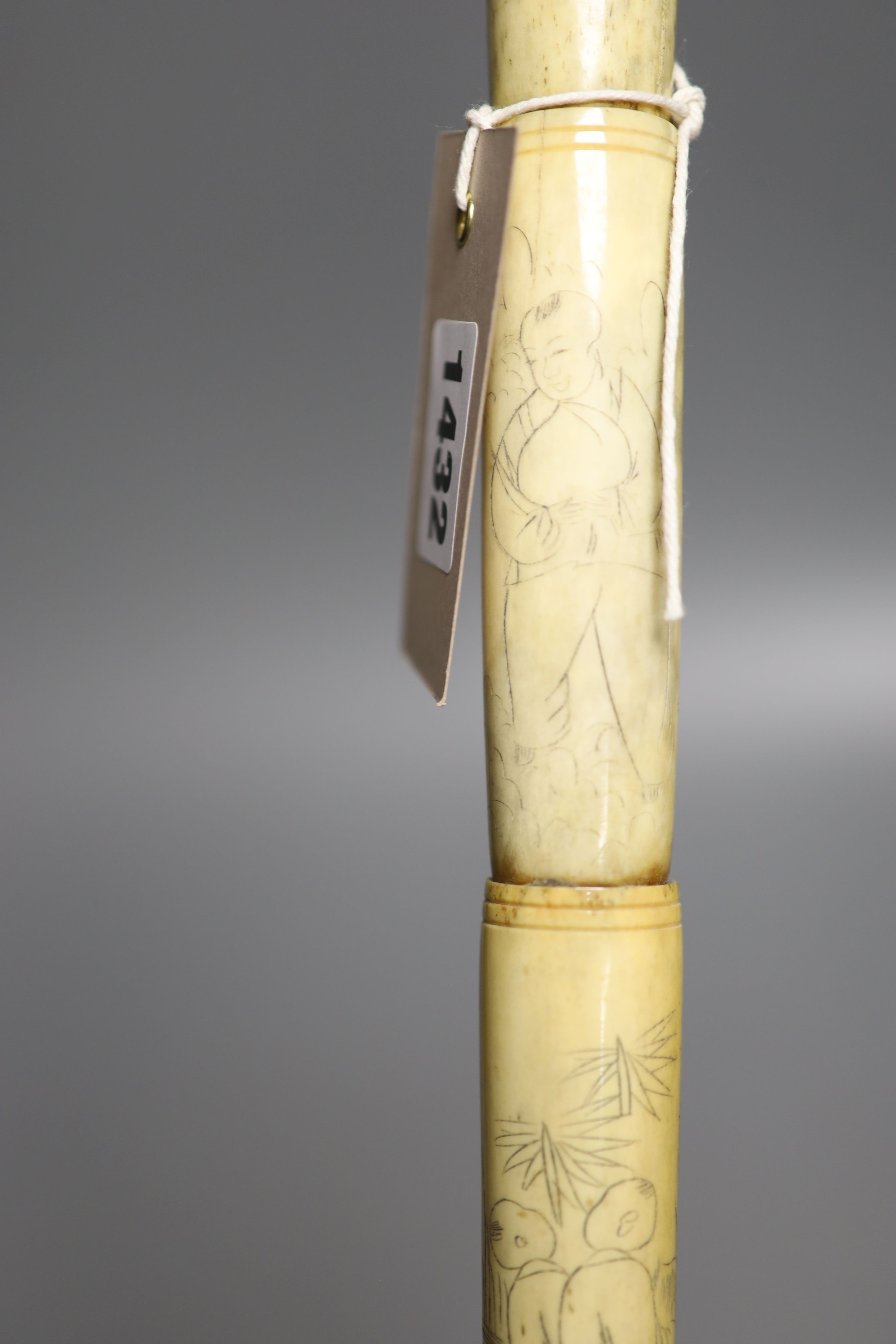 A Chinese engraved bone walking cane, 84cm